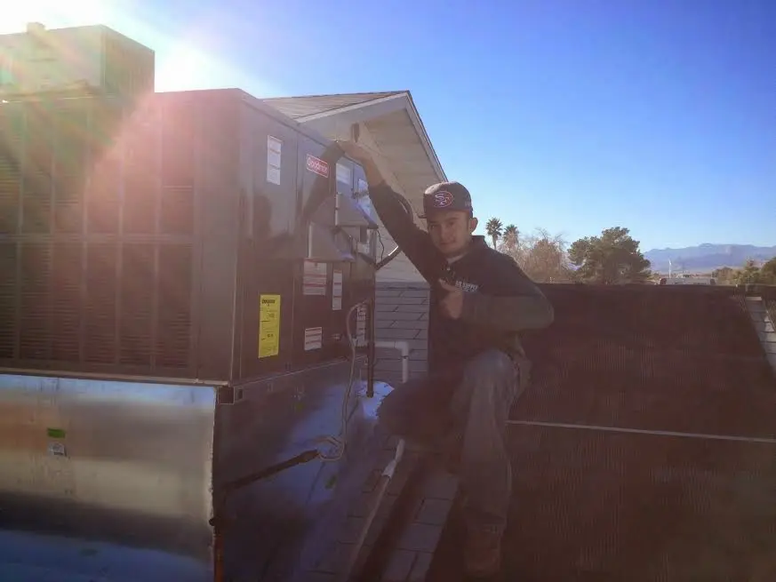 HVAC technician performing Heat Pump Repair on a rooftop unit in Big Flats